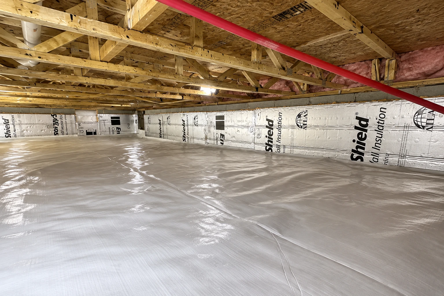 Crawl space with a plastic vapor barrier covering the floor and rigid insulation panels lining the foundation walls.
